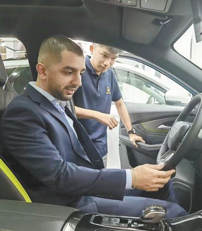 在阿联酋迪拜壹路集团汽车销售展厅,当地顾客体验东风风行品牌新能源汽车。本报记者 任皓宇摄